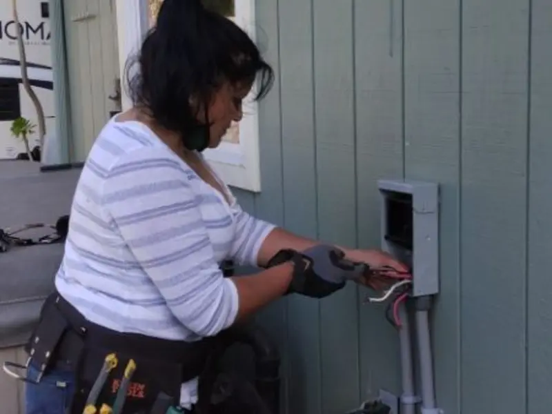 Licensed electrician wiring an exterior subpanel in Osage